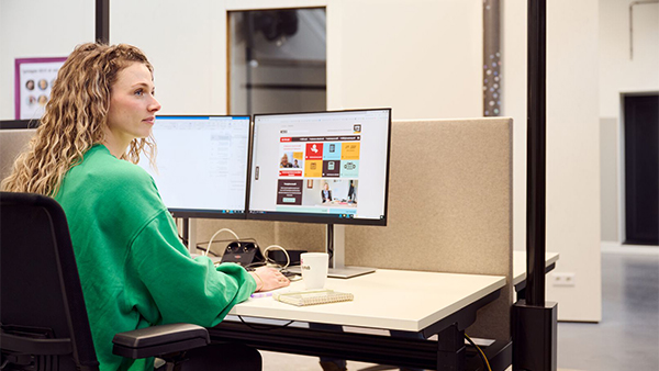 Vrouw achter bureau website van SPW op computerscherm